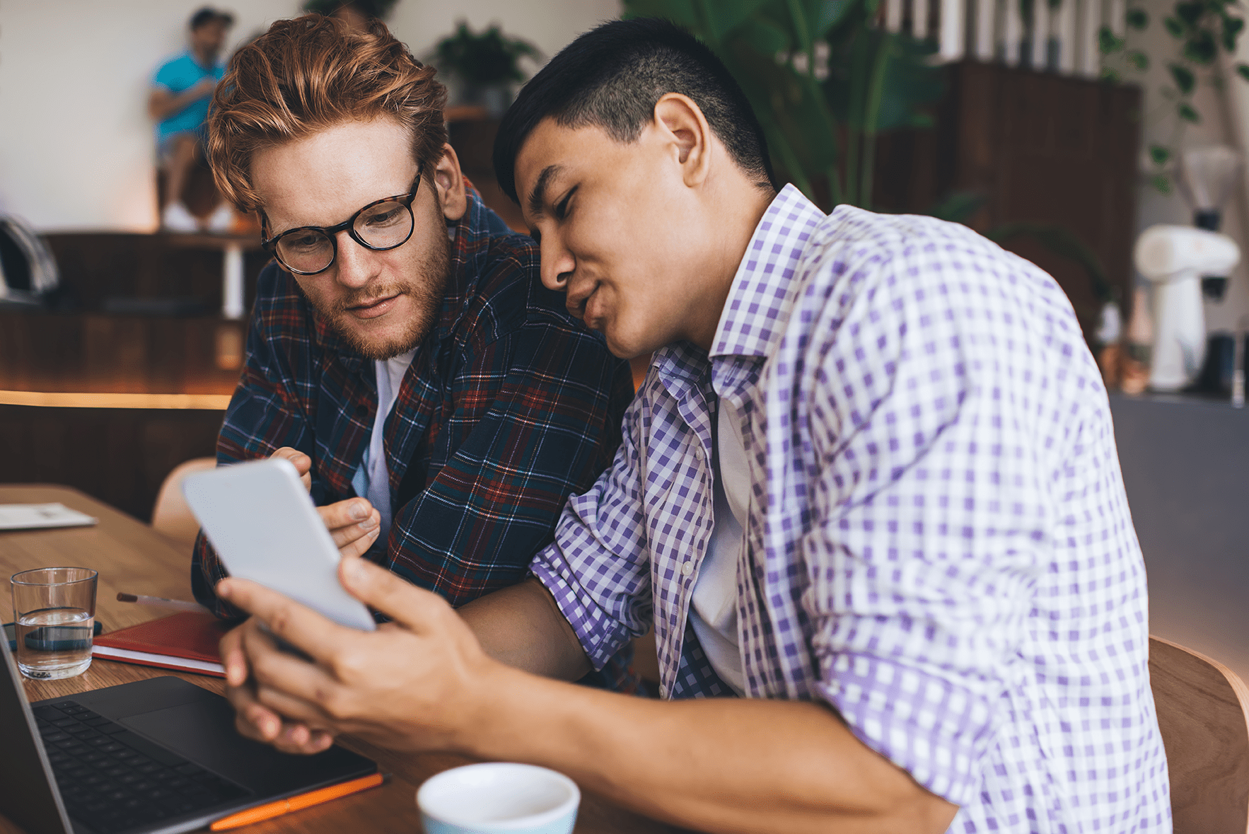 Ein Mann zeigt seinem Freund die KI-Anwendung auf seinem Telefon.