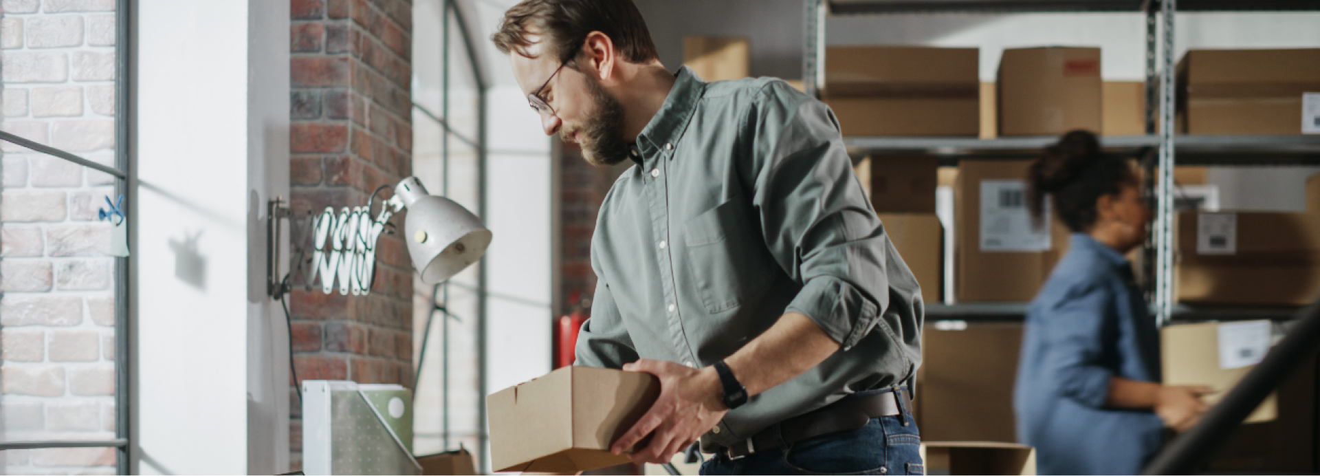 Ein Mann packt einen Karton.