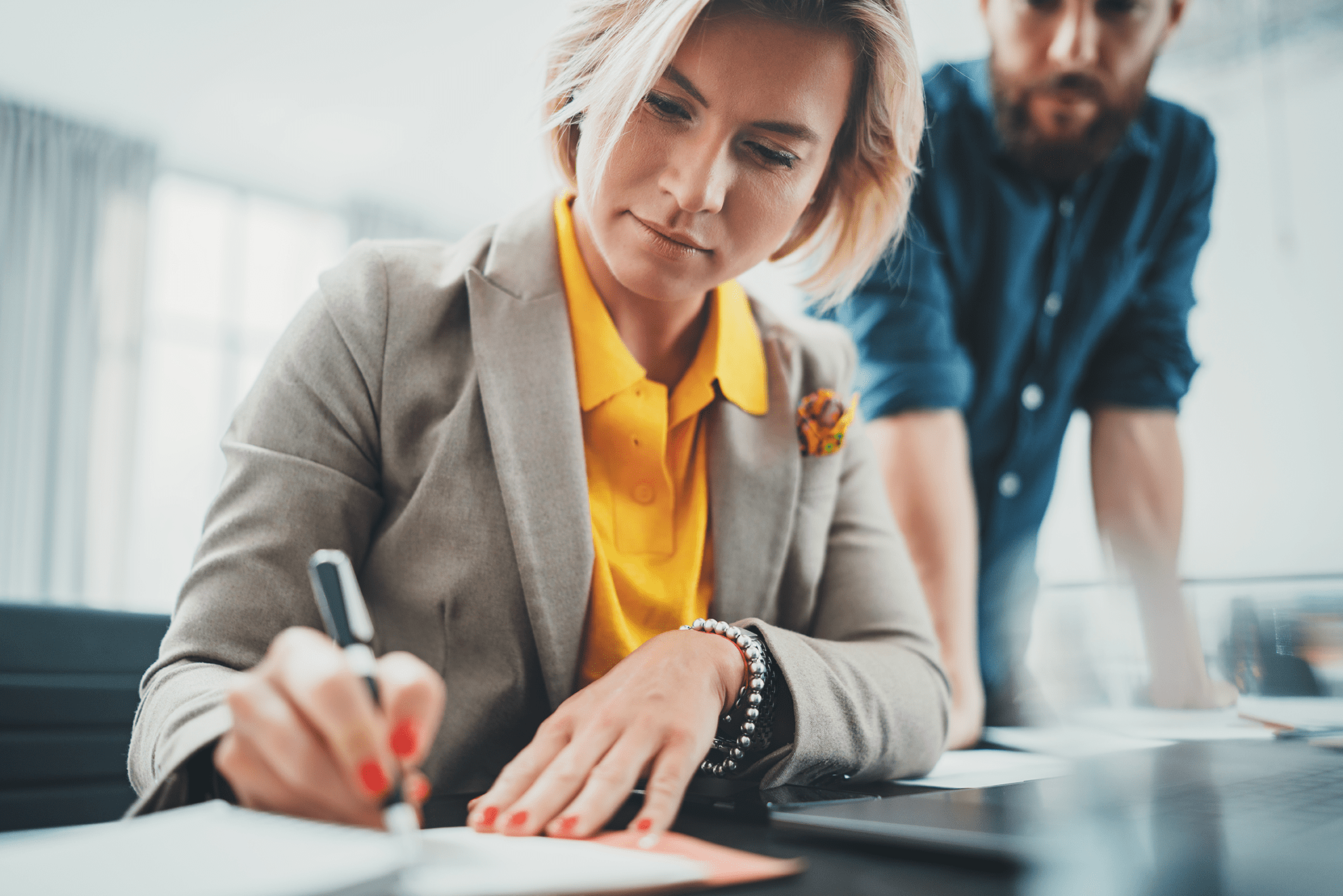 Eine Frau unterschreibt die Papiere.