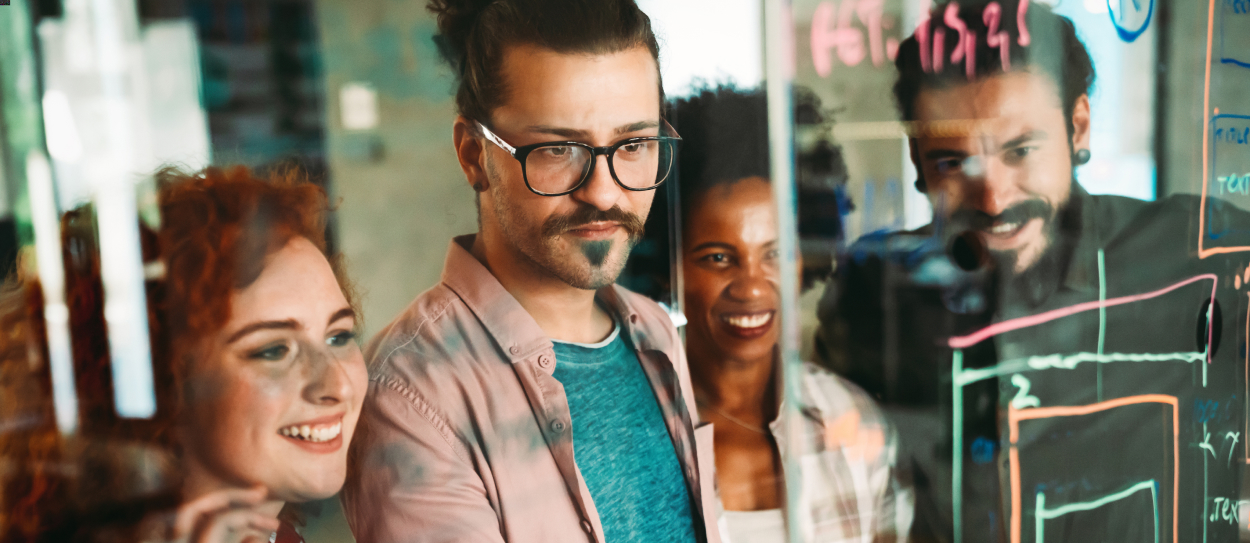 Das Team arbeitet gemeinsam an einer weißen Tafel.