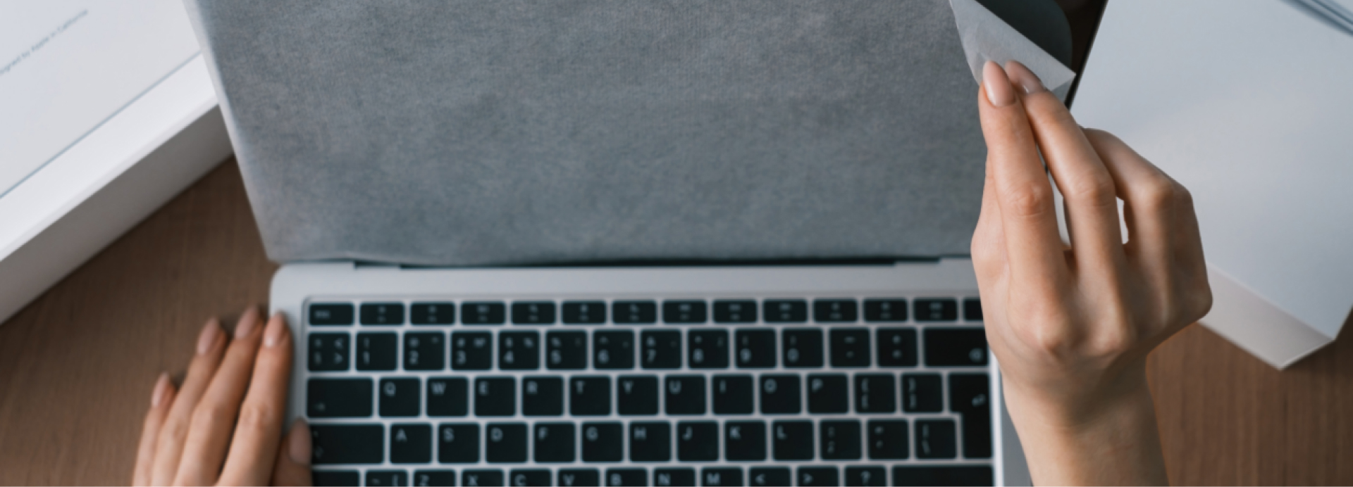 Eine Person packt einen neuen Laptop aus.