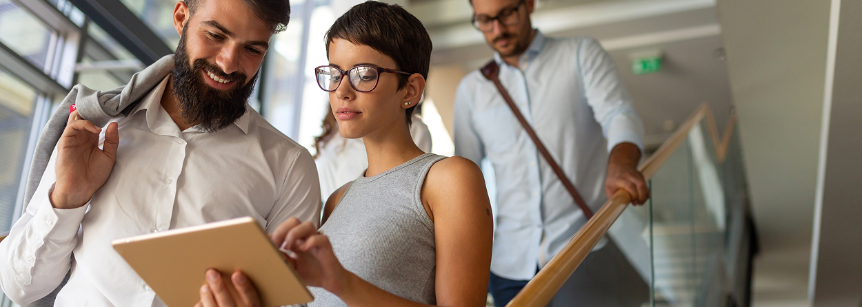 Frau mit einem Tablet, das ihrem Kollegen Daten zeigt