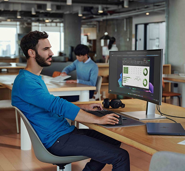 Ein Mann sitzt vor einem gro&szlig;en Bildschirm