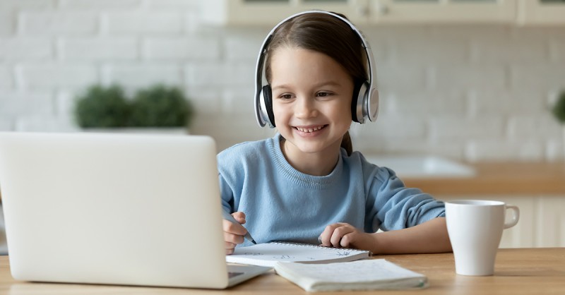 Smiling little girl study online using laptop