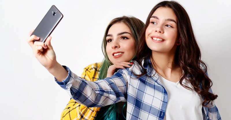 Two young women taking selfie with mobile phone