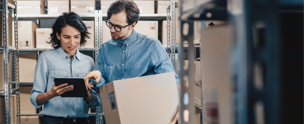 Two people in a warehouse looking at a tablet together